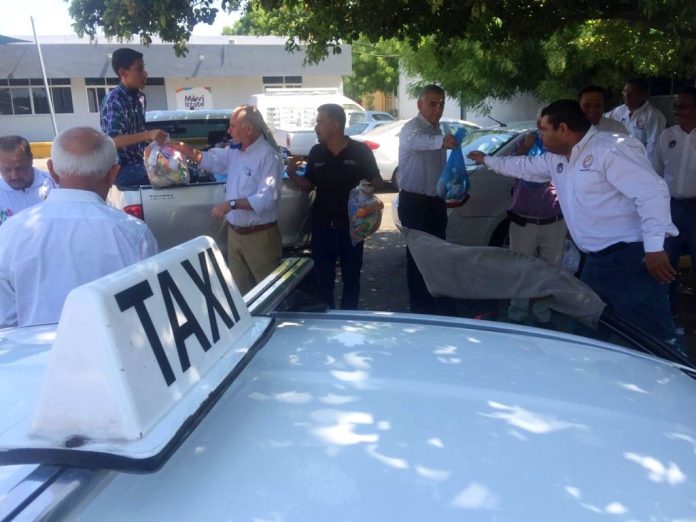 Sanitizan taxis y camiones urbanos para mitigar el Covid 19 y entregan despensas a choferes