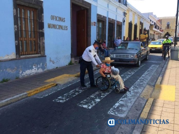 policia de colima ayuda a cruzar a persona con discapacidad