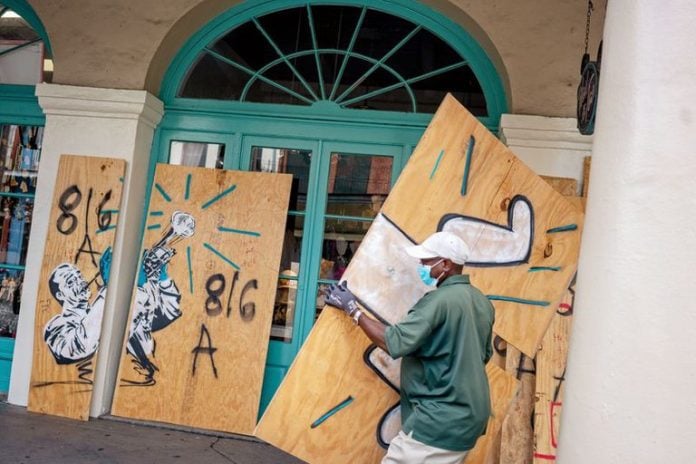 trabajador tapiando la entrada de un negocio en Nueva Orleans