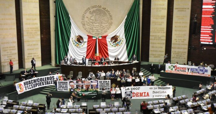 La bancada de Morena protesta contra su oposición en la Cámara de Diputados durante la sesión de este martes.