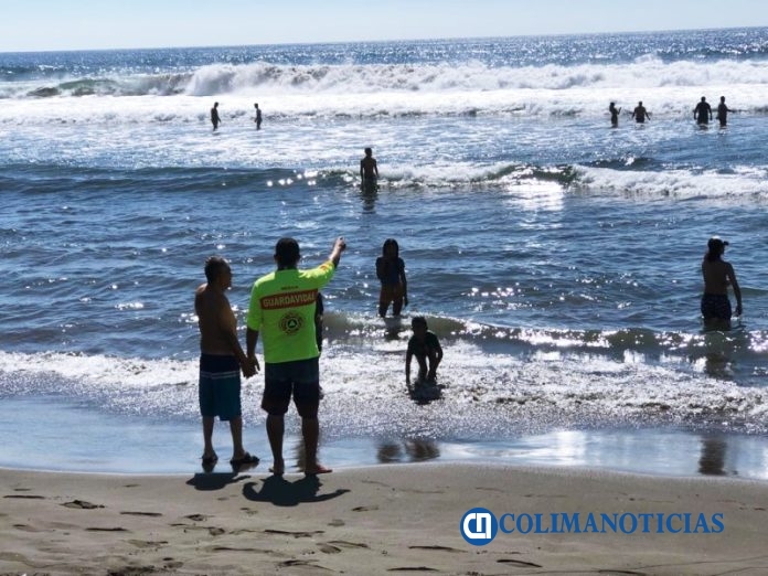 turistas en playa y guardavidas
