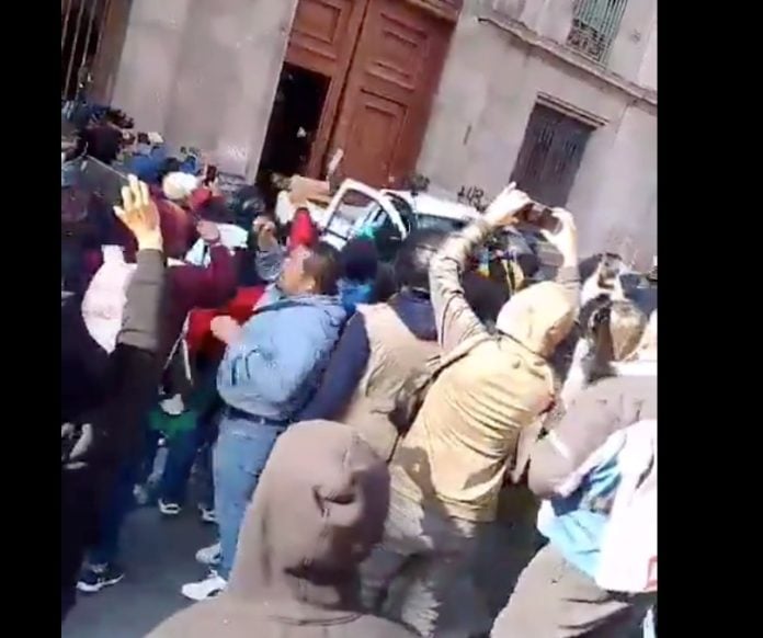 Normalistas de Ayotzinapa tiran puerta de Palacio Nacional